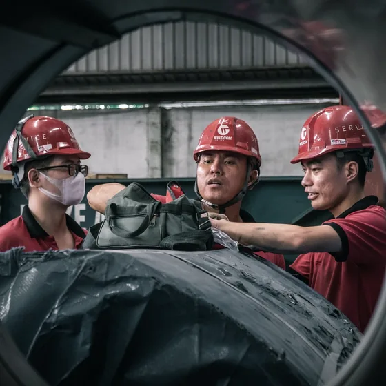 Equipe de capacete analisando um equipamento após ocorrência