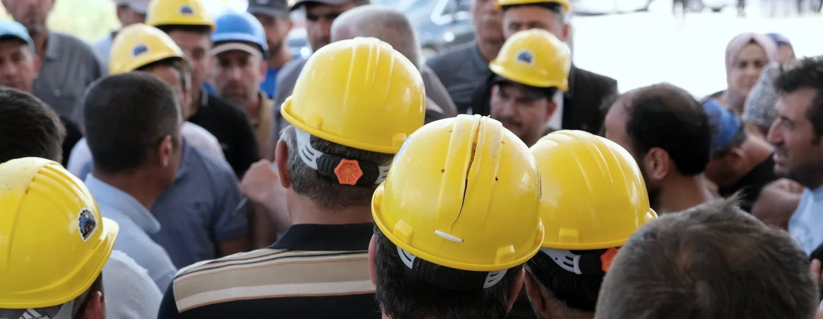 Equipe de capacete reunida ouvindo o diálogo diário de segurança